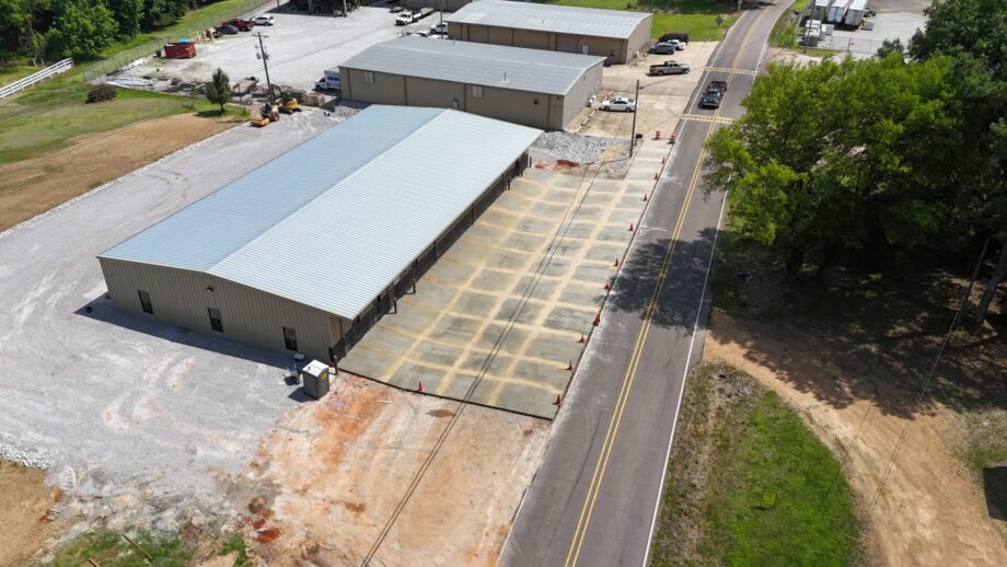 Aerial view of metal warehouse beside road